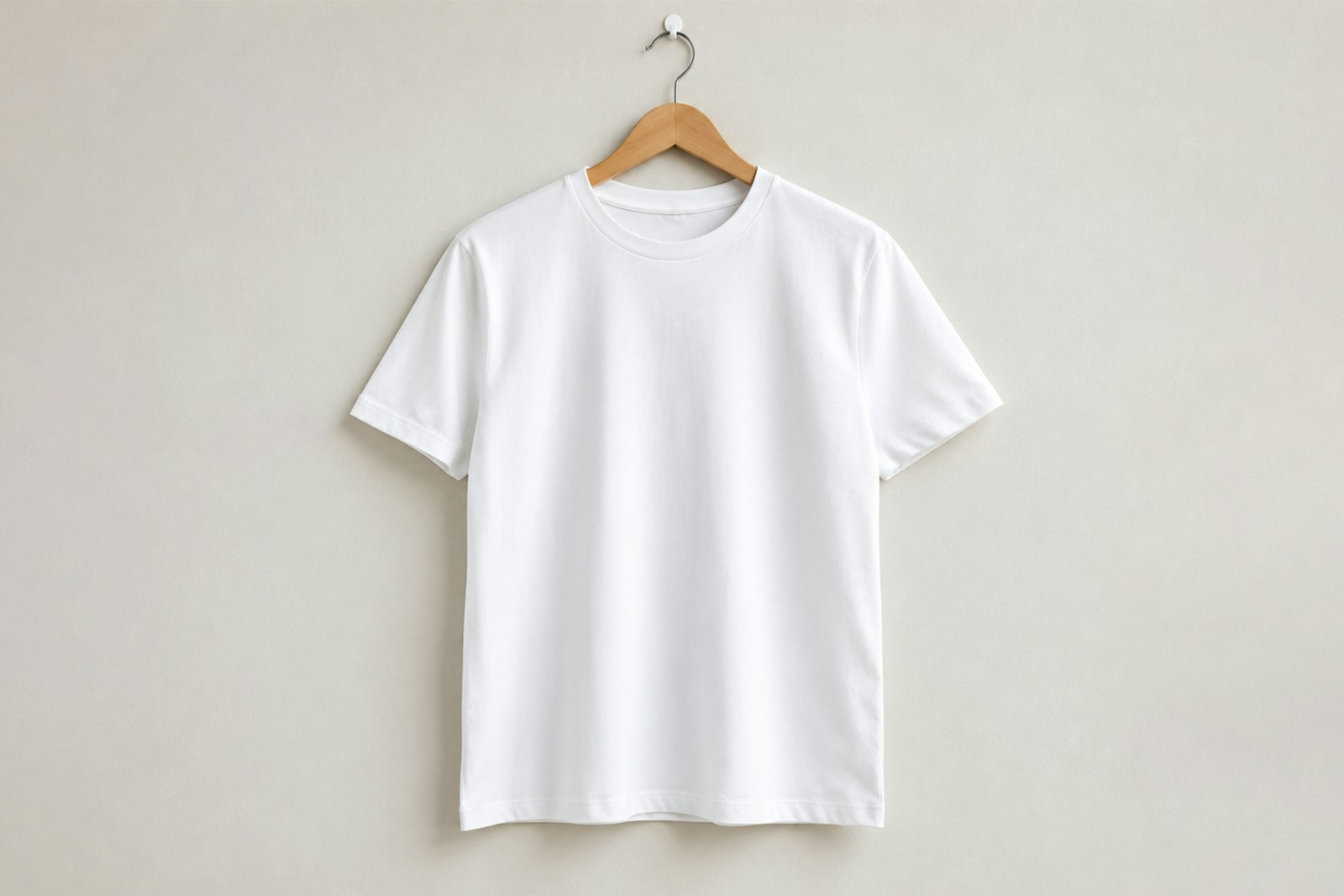 T-shirt blanc en coton suspendu à un cintre en bois, prêt à être personnalisé avec un symbole spirituel